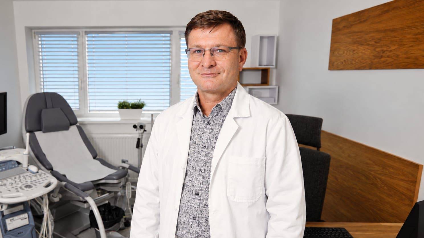 Doc. MUDr. Michal Otčenášek v ordinaci kliniky G-INNOVA s ultrazvukem a vyšetřovacím křeslem